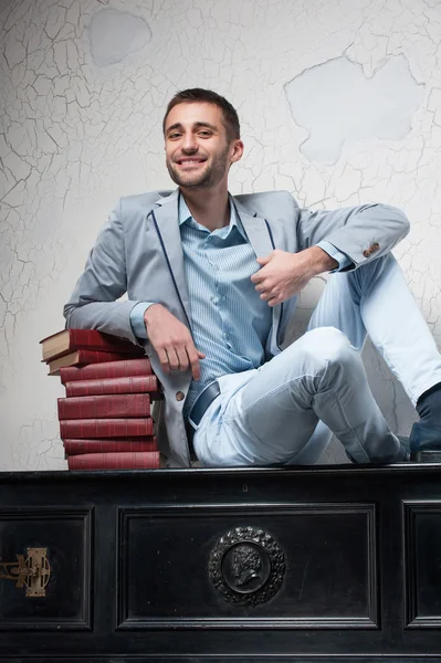 Young man with books sits on a piano — Stock Photo, Image