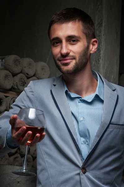 ワインのグラスと若い男が立っています。 — ストック写真