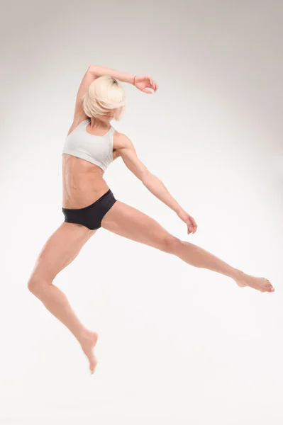 Sportliche Blondine zeigt akrobatische Übungen — Stockfoto