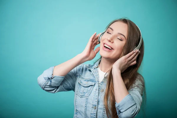 Cheerful Hipster woman is wearing headphones and listening to music