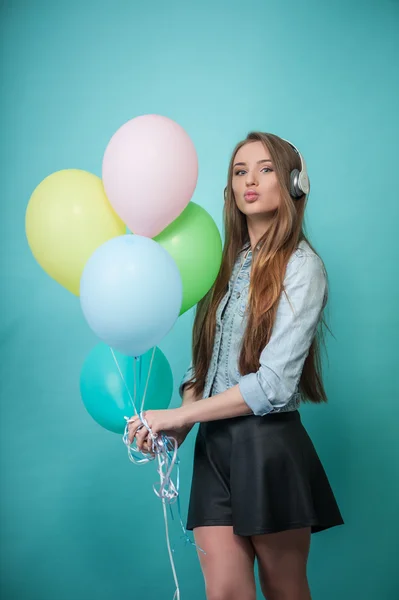 Весела жінка-хіпстер з навушниками та різнокольоровими кульками — стокове фото