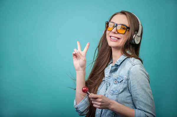 Cheerful Hipster woman with headphones and candy — Stock Photo, Image
