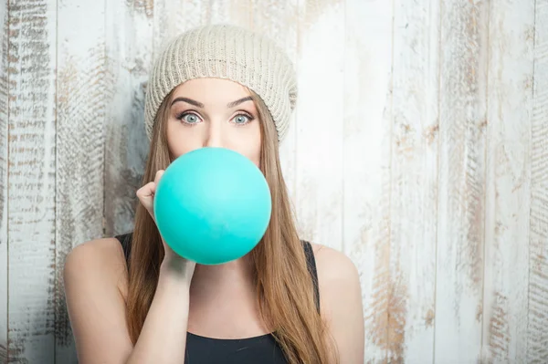 Bella donna hipster sta gonfiando palloncino colorato — Foto Stock