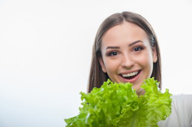 Oldukça sağlıklı kadın ile yeşil sebze duruyor