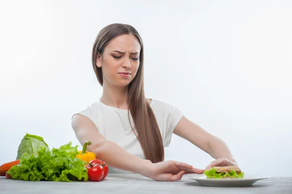 Glad ung tjej är att välja mellan sund och skadliga mat — Stockfoto