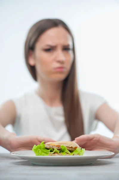 Beautiful young woman does not want to eat unhealthy food — Stock Photo, Image