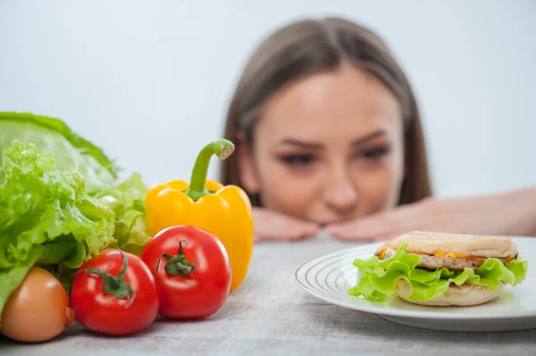 Mujer bonita elige entre comida sana y no saludable — Foto de Stock