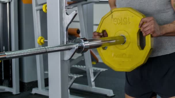 Esportista bonito está colocando peso em equipamentos de ferro — Vídeo de Stock