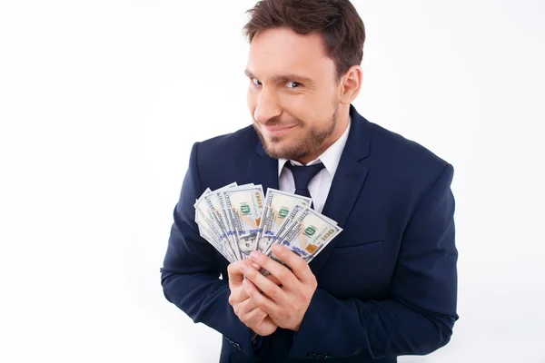 Attractive young man is keeping savings greedily — Stockfoto