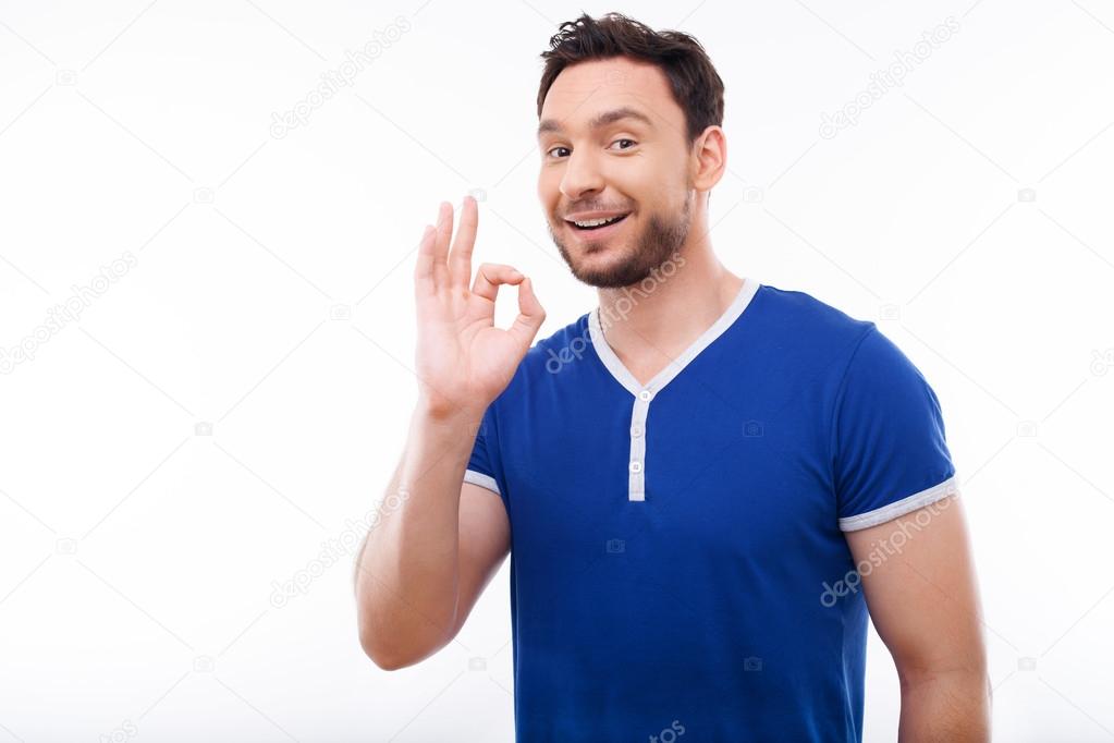 Cheerful young man is showing positive gesture