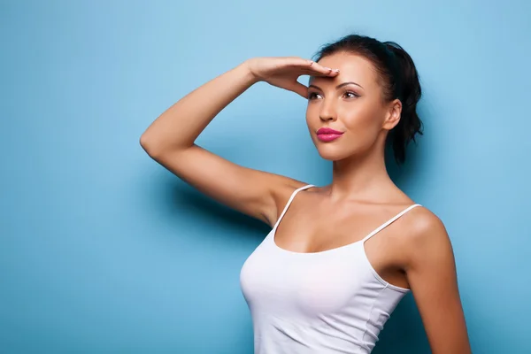 Cheerful young woman is trying to see something — Stock Photo, Image