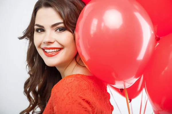 Beautiful young girl in red dress is making fun — Stock Photo, Image