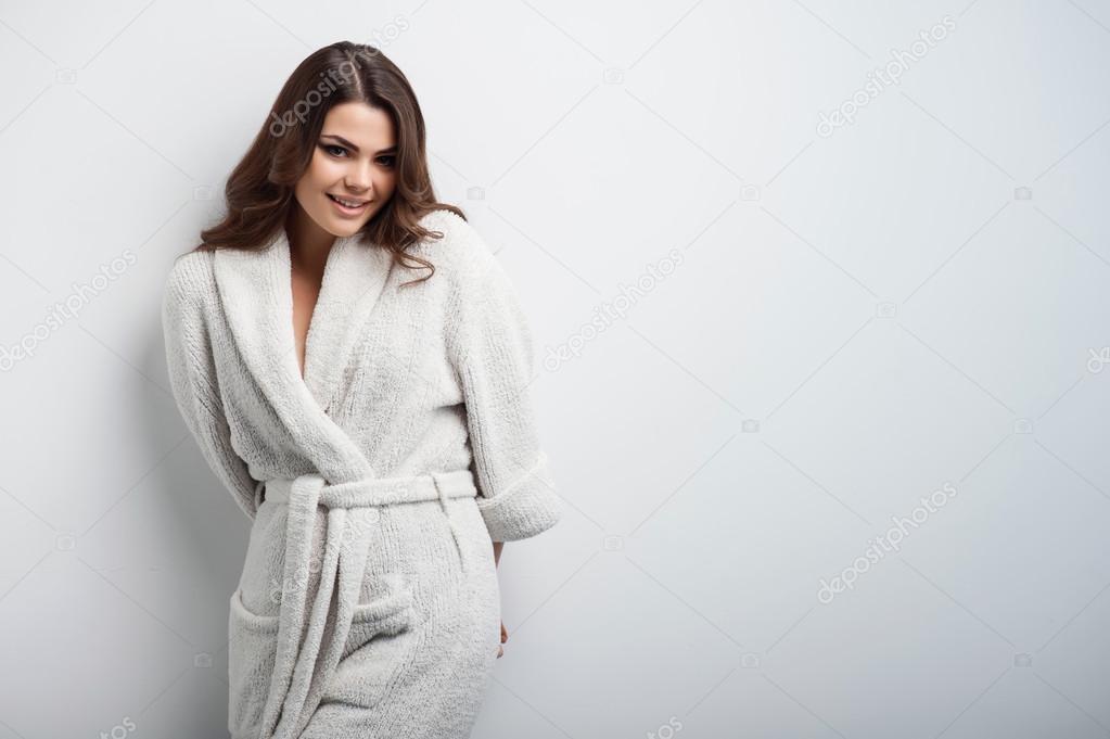 Beautiful young girl is standing in bathrobe