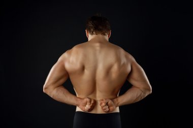 Attractive young bodybuilder is presenting his perfect body