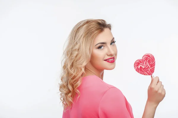 Attractive young girl with sweet pink candy — Zdjęcie stockowe