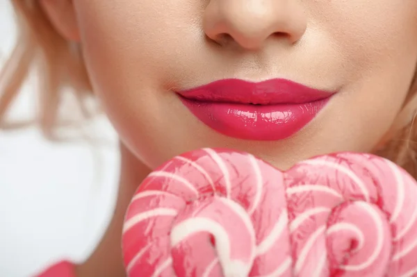 Beautiful young woman with sweet pink candy — Stock fotografie