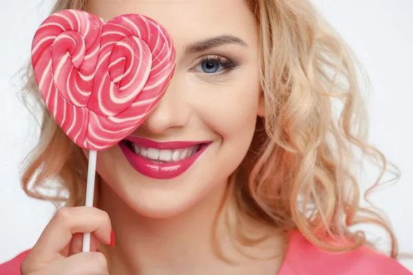 Attractive young woman is making fun with candy — Stok fotoğraf