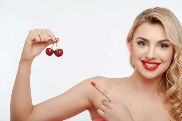 Cheerful young woman with two appetite cherries — Stock fotografie