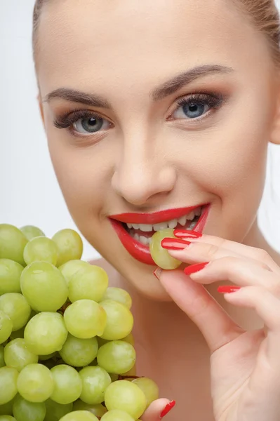 Beautiful young girl is tasting fresh fruit — ストック写真