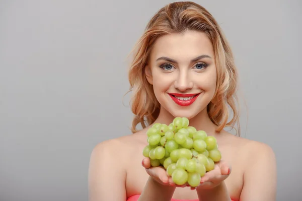 Cheerful young girl is presenting fresh green fruit — Stok fotoğraf