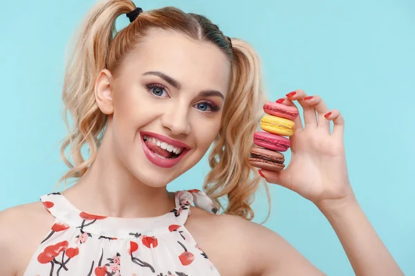 Cheerful young woman with sweet varicolored brownies — Stockfoto