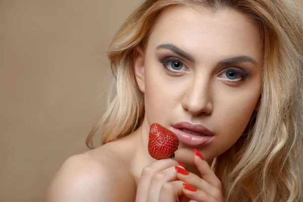 Beautiful young blond girl with red fruit — Stock fotografie