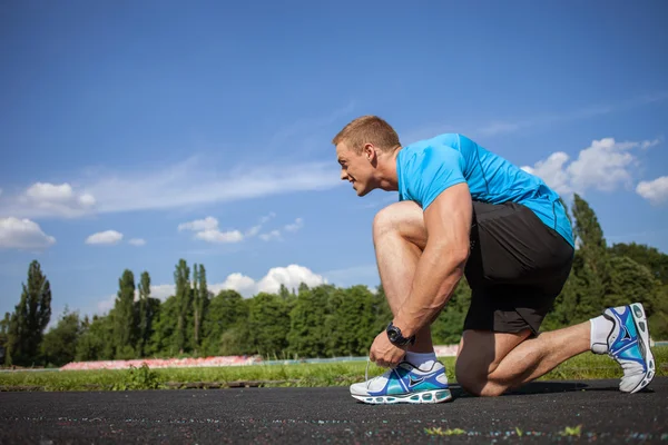 Cheerful young sportsman is preparing before running — ストック写真