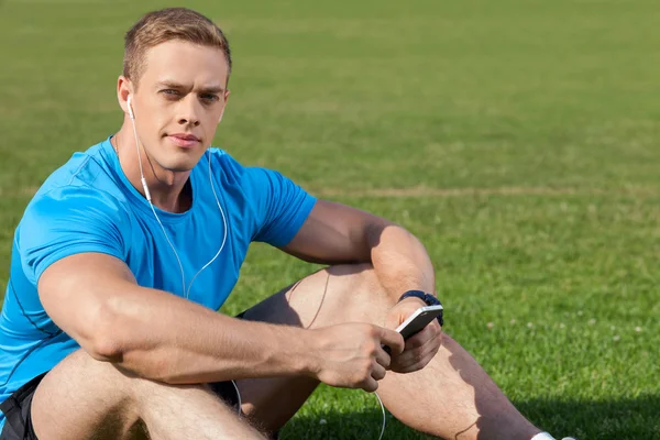 Atractivo joven atleta se relaja después de correr — Foto de Stock