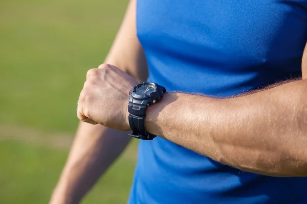 Young fit healthy sportsman is checking time — Stock Photo, Image