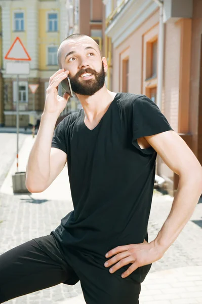 Handsome young man with beard in city — Stockfoto