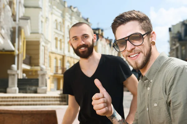 Handsome young hipster men are walking in city — Stockfoto