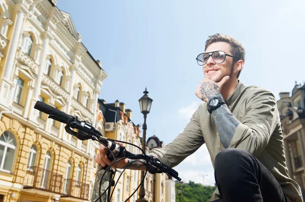 Handsome young hipster guy is cycling on street — Stockfoto