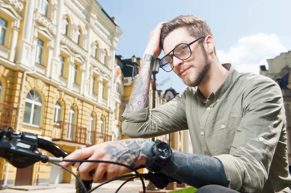 Attractive young man is cycling across city — Stockfoto