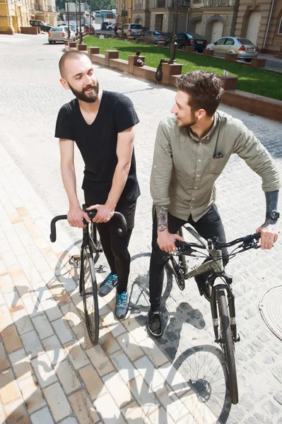 Attractive young hipster guys are cycling in city — Stockfoto