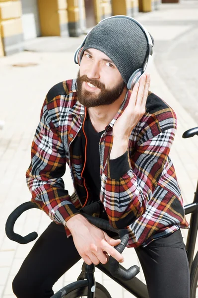 Handsome styled hipster guy is sitting on bicycle — Stock Photo, Image