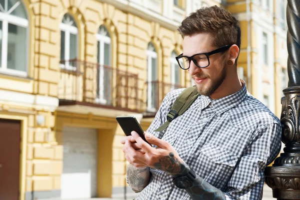 Handsome young tourist with backpack and glasses — Stockfoto