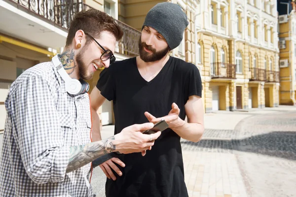 Two cheerful young friends are talking in city — Stockfoto