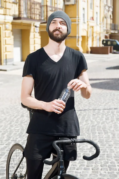 Attractive young hipster guy is cycling in city — Stockfoto