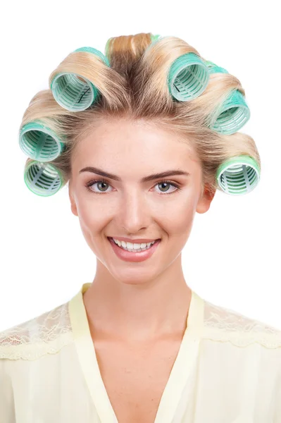 Cheerful young woman with rollers in her head — Stockfoto