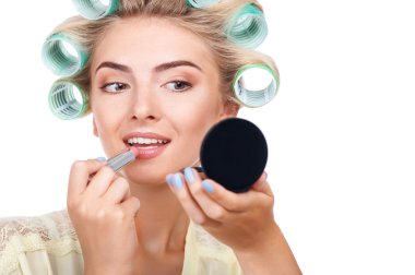 Attractive young girl is doing make-up and hairstyle