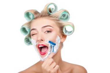 Beautiful young housewife with curlers is making fun