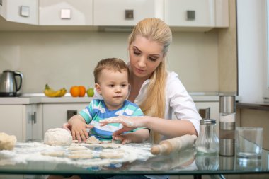 Genç güzel anne çocuğunu yemek yapmayı öğretiyor