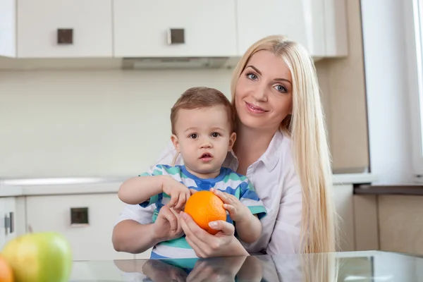 Alegre jovem mãe está alimentando seu filho — Fotografia de Stock