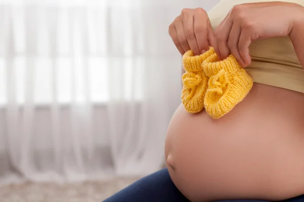 Jovem mãe grávida saudável com pequenos galos de bebê amarelo — Fotografia de Stock