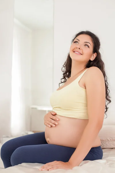 Bastante joven embarazada madre está soñando con el futuro — Foto de Stock