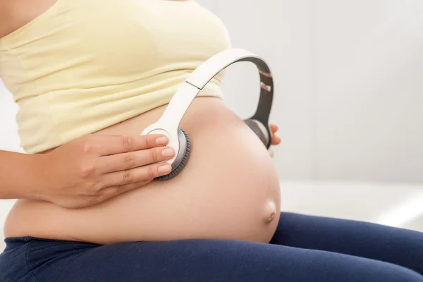 Young healthy pregnant woman is making therapy for her baby — Stock Fotó