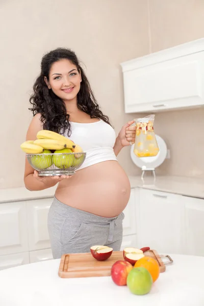 Cheerful young expectant mother is preparing a breakfast — Stock Fotó