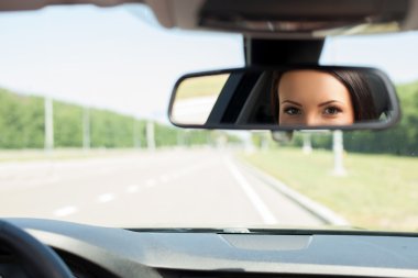 Cheerful young woman is driving her car