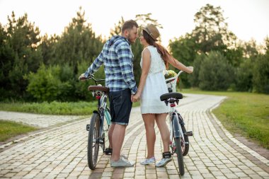 Pretty young loving couple is walking in park