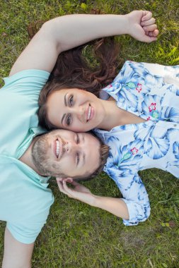 Beautiful girlfriend and attractive boyfriend are lying in the nature